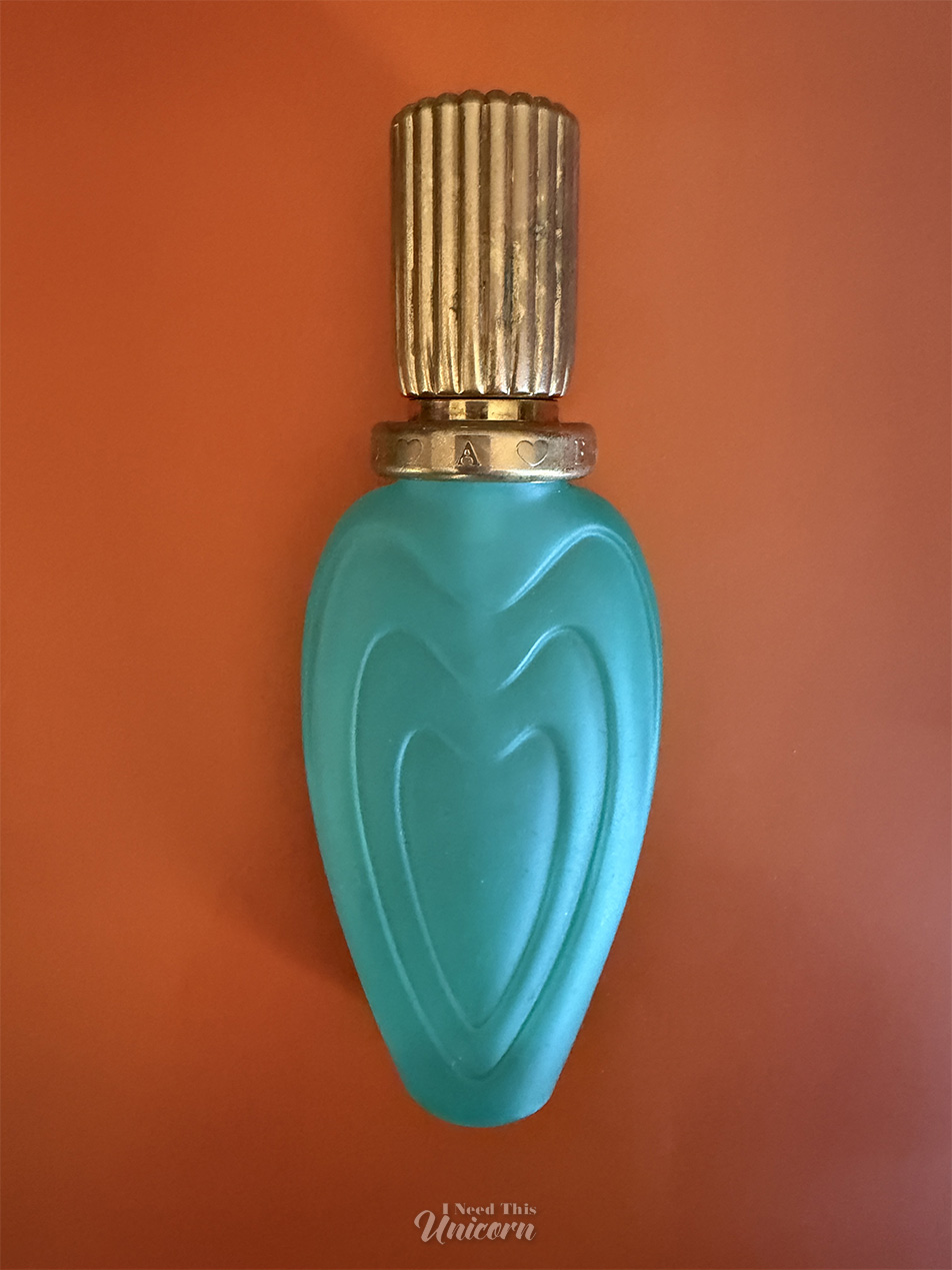 Bottle of the elusive Escada Blue Romance from 1995. Aqua blue bottle on an orange background.