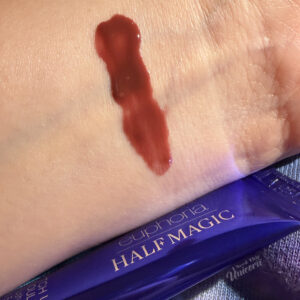 Half Magic Euphoria B*tch You’re My Soulmate Extra Plush Lip Gloss swatch on arm, against a galaxy background.