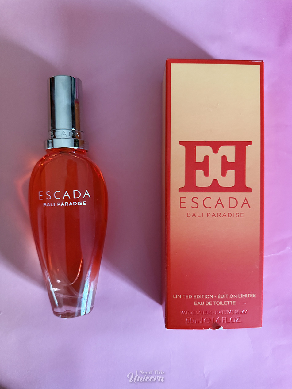 Red-orange bottle of Escada Bali Paradise and it's box on a pink background