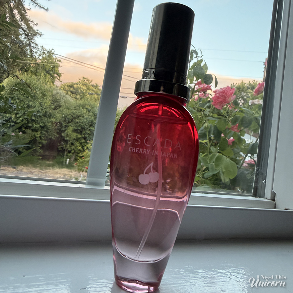 Escada's Cherry in Japan red gradient bottle on a window sill