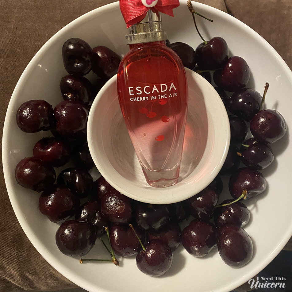 Cherry In The Air fragrance bottle in a bowl of cherries