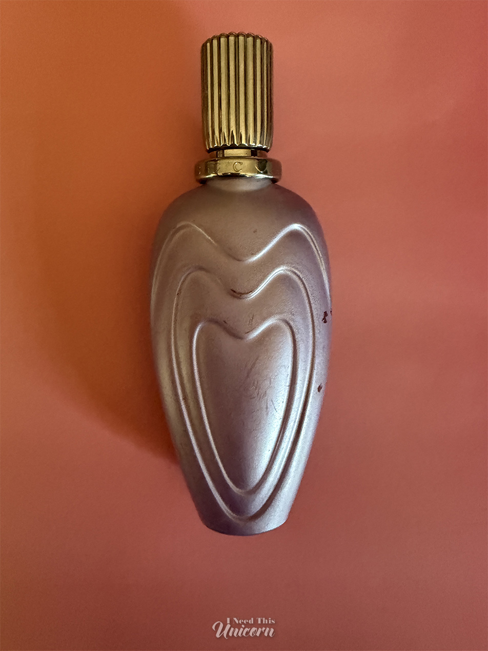 Pearlised lavender bottle of Escada's Loving Bouquet on an orange background