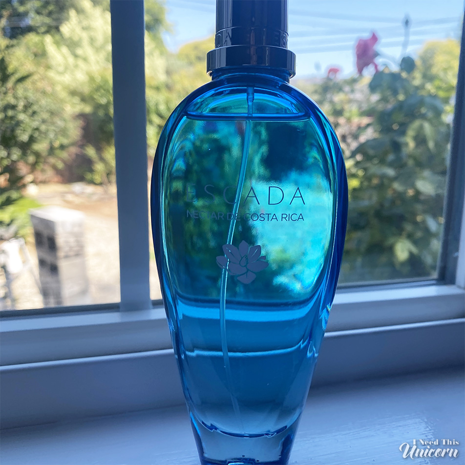 Blue bottle of Escada Necar de Costa Rica sitting on a window sill