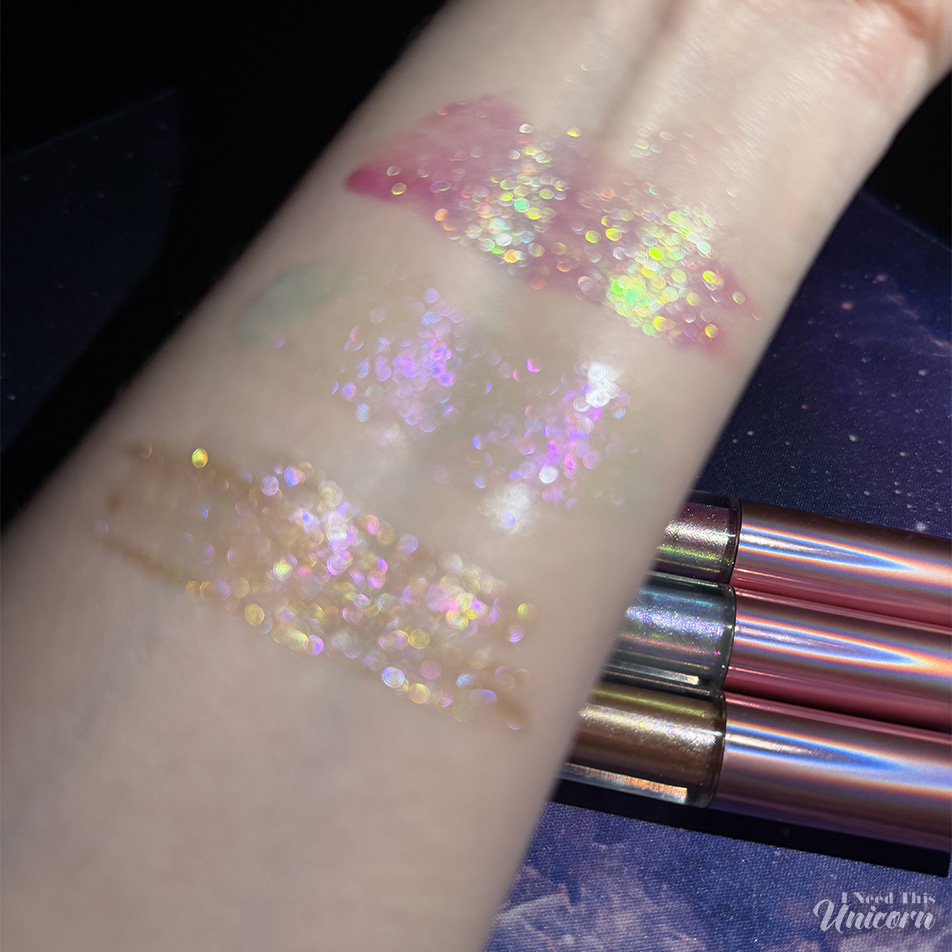 Queen Cosmetics Tester Diamond Shimmer Glosses | I Need This Unicorn Blurry flash photo of Queen Cosmetics Tester #1, Tester #2, and Tester #3 Diamond Shimmer lip gloss swatches, highlighting the multi-dimensional sparkle and color-shifting shimmer particles.