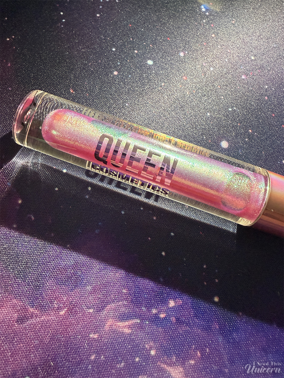 Queen Cosmetics Tester Diamond Shimmer Glosses | I Need This Unicorn Closeup detail shot of Tester #1 by Queen Cosmetics in the tube on a galaxy printed mouse pad with direct flash light