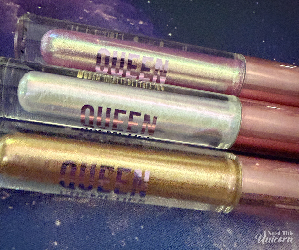 Queen Cosmetics Tester Diamond Shimmer Glosses | I Need This Unicorn Queen Cosmetics Tester #1, Tester #2, and Tester #3 Diamond Shimmer lip glosses photographed on a galaxy background, showing their pink, opal, and gold color shifts.
