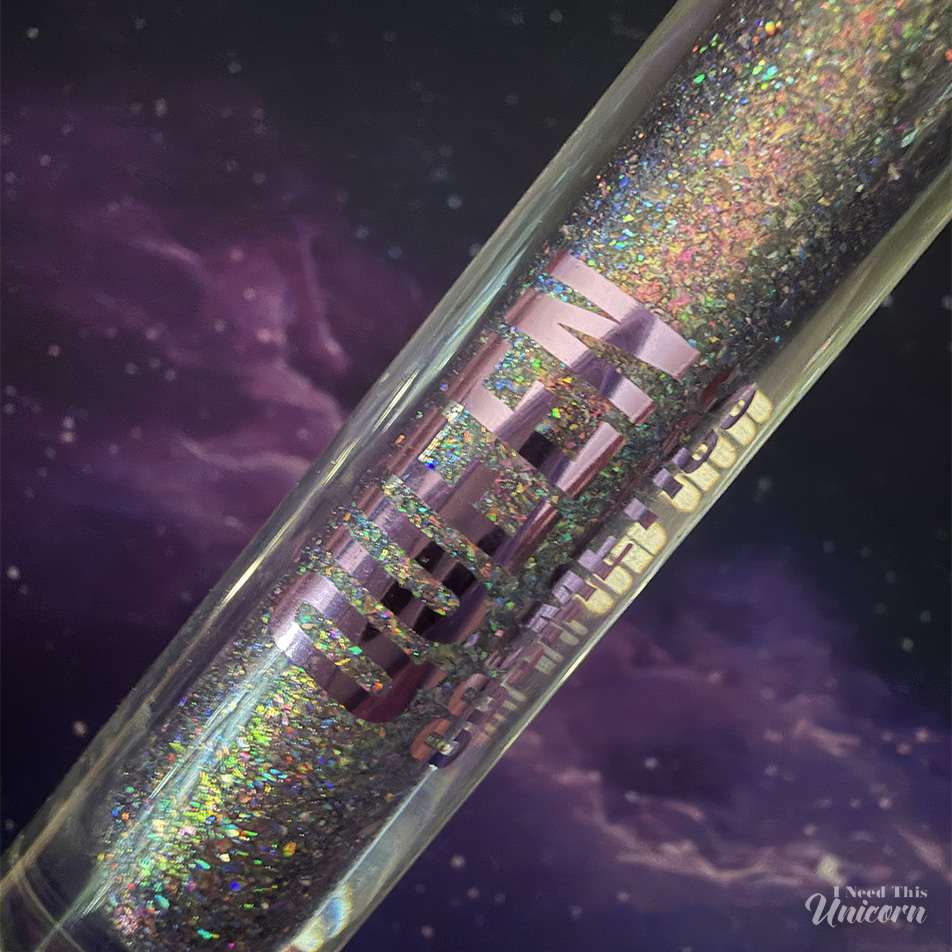 Queen Cosmetics Tester Diamond Shimmer Glosses | I Need This Unicorn Digital Doll holographic lip gloss by Queen Cosmetics showing rainbow reflective flakes in the tube