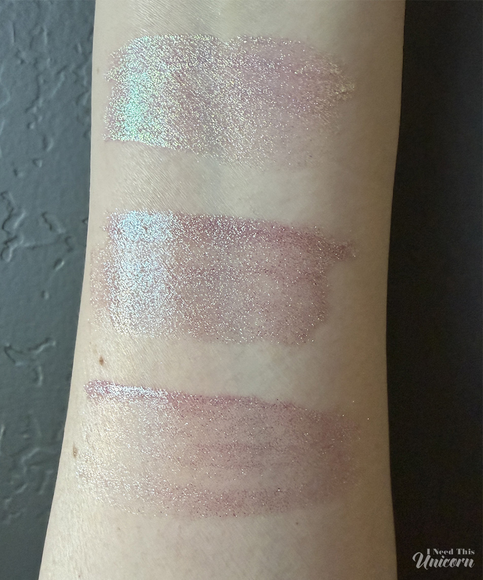 Indoor swatches of Queen Cosmetics Tester #1 (top) and two Moonstone glosses (middle and bottom), highlighting differences in sparkle density, pink tones, and reflective shimmer.