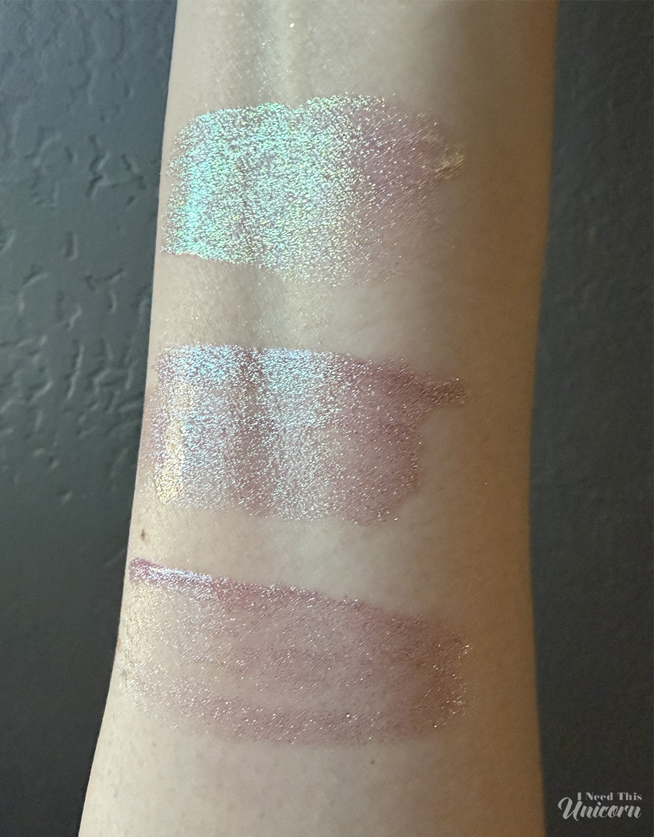 Indoor swatches of Queen Cosmetics Tester #1 (top) and two Moonstone glosses (middle and bottom), highlighting differences in sparkle density, pink tones, and reflective shimmer.