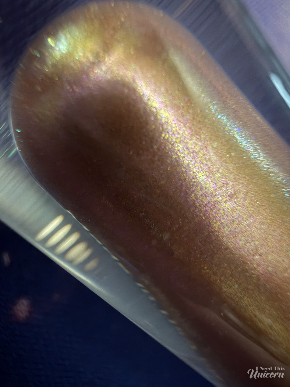 Queen Cosmetics Tester Diamond Shimmer Glosses | I Need This Unicorn Macro photograph of the detail of shimmer in Tester #3, with gold, pink and even aqua shimmers in the tube.