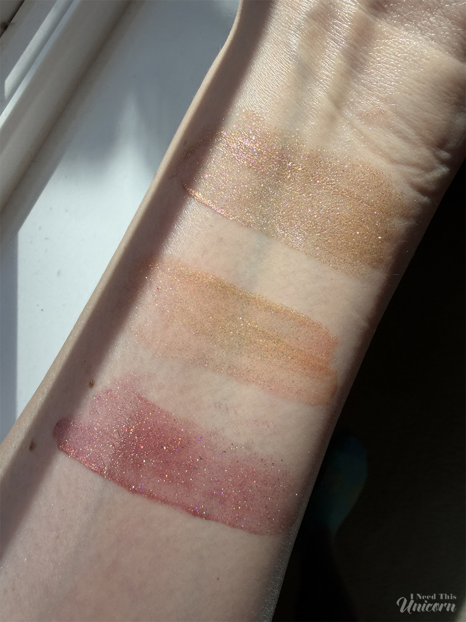 Daylight swatches of Queen Cosmetics Tester #3 compared with Aphrodite and Face Time. Tester #3 reveals a pink-champagne iridescent shift, Aphrodite appears more yellow-gold and metallic, while Face Time provides a natural rosy nude tint with delicate shimmer.